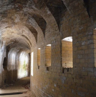 Kyiv Fortress in Kyiv - long curved brick tunnel with light streaming through loopholes
