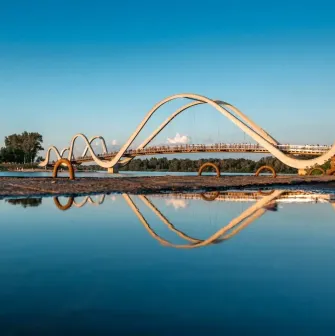 Azov Wave Bridge in Kyiv - white wave-shaped bridge reflecting in the water surface
