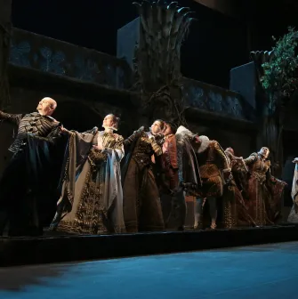 Teatr Lesi Ukrainky in Kyiv - theatrical performance with a group of actors in Renaissance costumes standing in a row against a backdrop of castle ruins