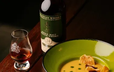 A dish and a glass of whisky on a wooden table at the "Whisky Corner" bar in Kyiv.