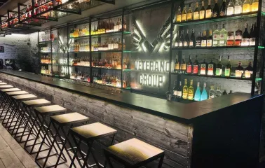 Modern restaurant bar counter with illuminated shelves and bottles