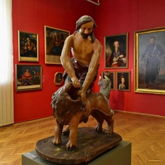National Art Museum of Ukraine in Kyiv - a sculpture of Samson tearing open the mouth of a lion stands in a hall with portraits