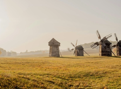 Pyrohiv Museum in Kyiv - line of traditional wooden windmills on open grassland