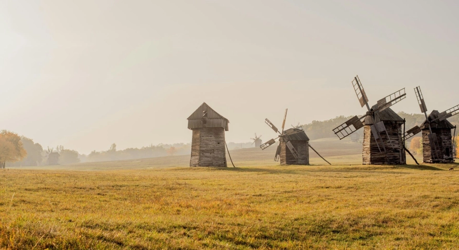 Pyrohiv Museum in Kyiv - line of traditional wooden windmills on open grassland