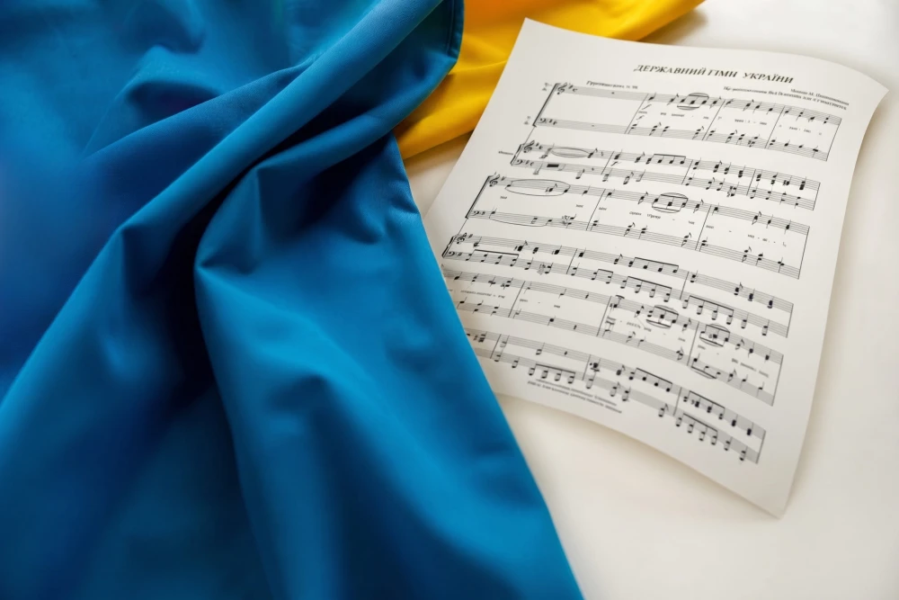 Sheet music of the Ukrainian national anthem on a blue-yellow flag background