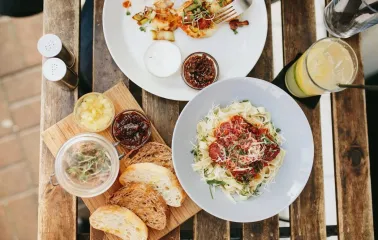 Bar Restaurant Kosatka - overhead shot of pasta bread and appetizers on an outdoor table