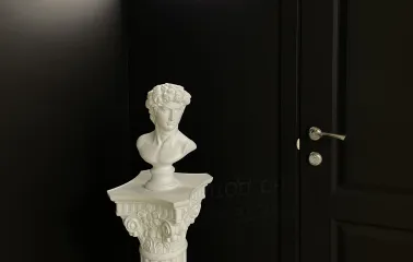 Muzei u Temriavi in Kyiv - classical white plaster bust standing on a column against a black background highlighting the concept of art in the dark