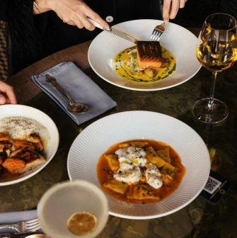Restaurant Italiiska Redaktsiia - top-down view of pasta salmon and wine on a table