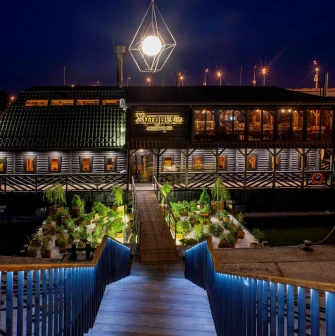 Restaurant Khutorets na Dnipri - exterior view of the restaurant at night over the water