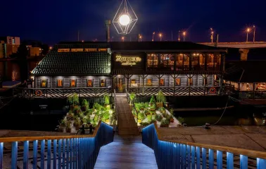 Restaurant Khutorets na Dnipri - exterior view of the restaurant at night over the water