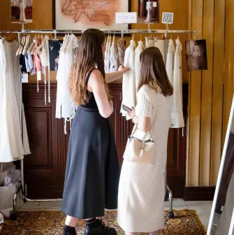 Visitors look at clothes on hangers in the Eatmyvintage market area