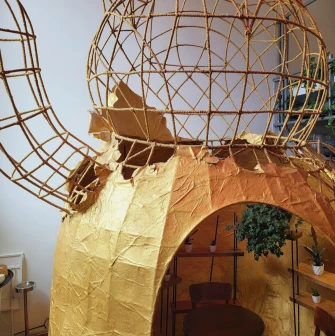 Restaurant Kytaiskyi Pryvit - large cat-shaped metal and paper sculpture with a small seating area inside