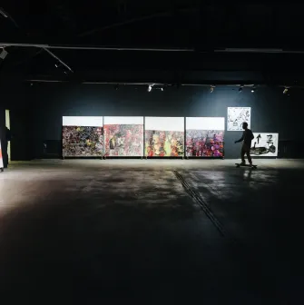 Lavra Gallery in Kyiv - dark industrial exhibition space with abstract paintings and a person on a skateboard