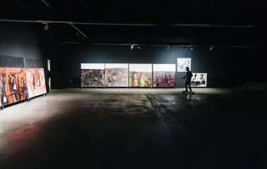 Lavra Gallery in Kyiv - dark industrial exhibition space with abstract paintings and a person on a skateboard