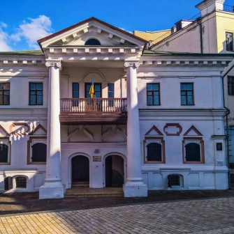 Muzei Hetmanstva in Kyiv - historic white manor house featuring a classic columned portico and a balcony with a Ukrainian flag