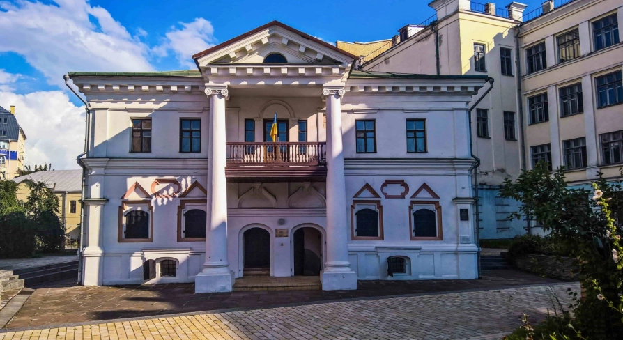 Muzei Hetmanstva in Kyiv - historic white manor house featuring a classic columned portico and a balcony with a Ukrainian flag