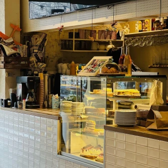 Trishky Bilshe – dessert showcase with cakes and croissants in cozy cafe interior