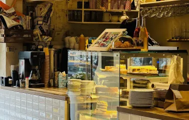 Trishky Bilshe – dessert showcase with cakes and croissants in cozy cafe interior