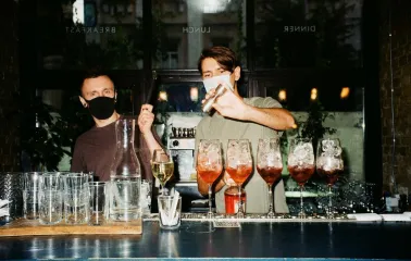 Bar Restaurant Kosatka - two bartenders wearing masks making and shaking drinks behind a counter
