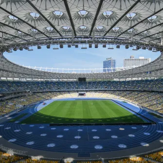 NSC Olimpiyskiy in Kyiv - majestic interior view of the stadium featuring the iconic glass roof structure with a central opening above the green pitch and thousands of seats