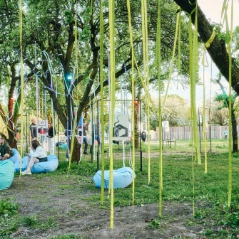 Vyava in Kyiv - garden art installation featuring yellow ribbons hanging from trees and posters displayed on wire panels