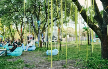 Vyava in Kyiv - garden art installation featuring yellow ribbons hanging from trees and posters displayed on wire panels