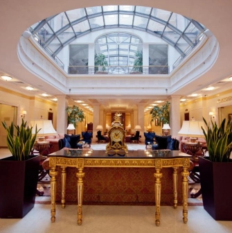 Interior of the Opera Hotel lobby in Kyiv with a golden table and a glass roof