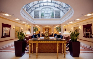 Interior of the Opera Hotel lobby in Kyiv with a golden table and a glass roof