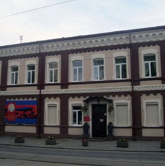 Muzei Suchasnoho Mystetstva in Kyiv - historic building facade combining maroon and beige brickwork with the museum signage near the entrance