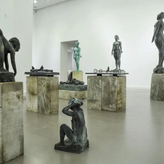 Muzei Suchasnoho Mystetstva in Kyiv - bright gallery hall displaying a collection of modern bronze sculptures on rough stone pedestals