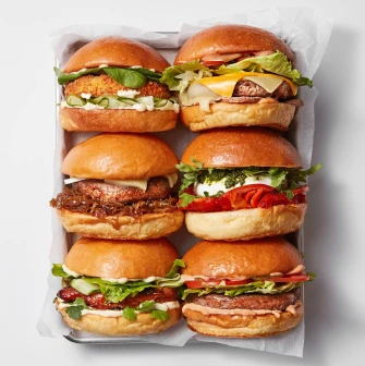 Six different burgers on paper at Holy Burger