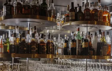 Bar shelves with bottles of alcoholic beverages and glasses