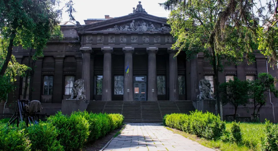 Natsionalnyi Khudozhnii Muzei Ukrainy in Kyiv - majestic dark grey classical facade with a Greek portico and lion sculptures guarding the entrance stairs