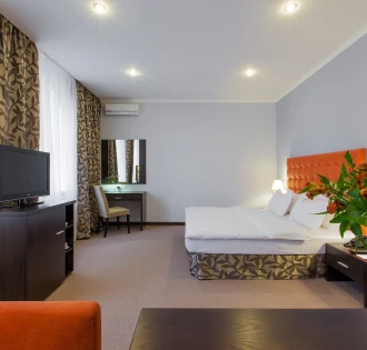 Comfort room with an orange headboard and flowers at Bontiak Hotel