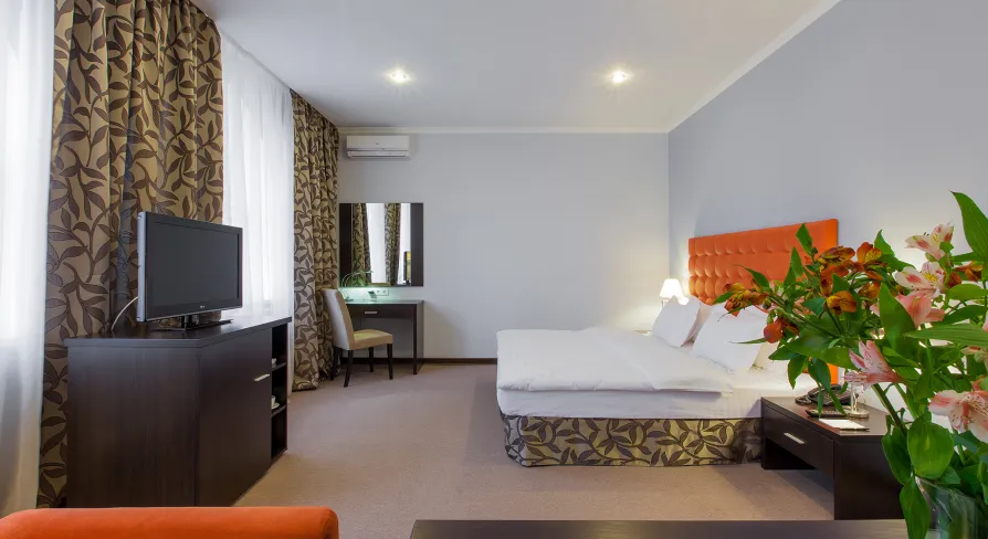 Comfort room with an orange headboard and flowers at Bontiak Hotel