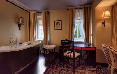 Vozdvyzhenskyi in Kyiv - bathroom with freestanding tub and black desk by window
