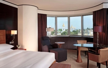 Room at Hyatt Regency Kyiv with panoramic views of St. Michael's Cathedral and a cozy seating area