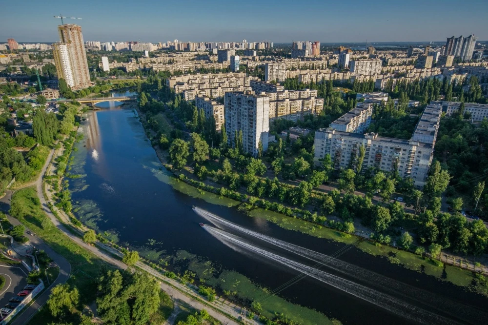 Rusanivska Naberezhna in Kyiv - aerial sunny view of the residential district surrounded by a wide blue canal and lush green trees
