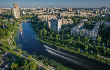 Rusanivska Naberezhna in Kyiv - aerial sunny view of the residential district surrounded by a wide blue canal and lush green trees