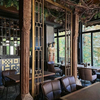 Restaurant Chary - interior with carved wooden columns and brown leather chairs