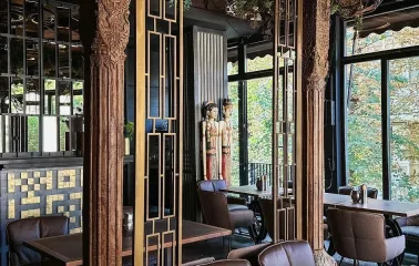 Restaurant Chary - interior with carved wooden columns and brown leather chairs