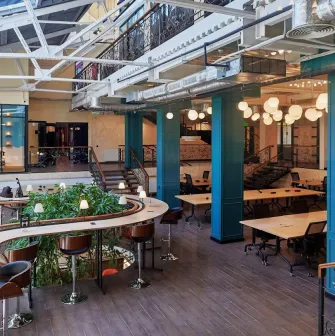 Creative States - modern workspace featuring high ceilings and long desks