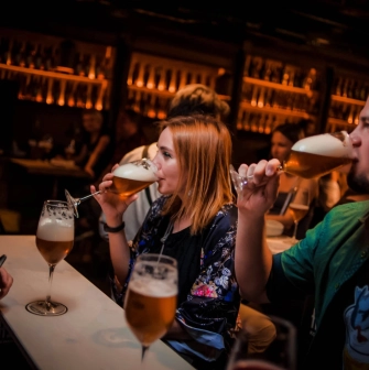 Pab Kedy - people drinking beer from goblets at a bright bar counter