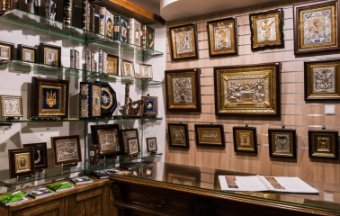 Narodnyi Dim Ukraina in Kyiv - display wall showcasing religious art with silver and gold framed icons and leather-bound books