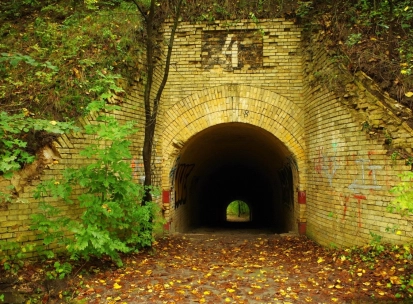 Lysa Hora in Kyiv - view through an old brick tunnel archway surrounded by autumn leaves