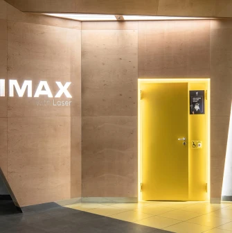 Дерев'яна стіна з логотипом IMAX with Laser та жовтими дверима