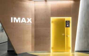 Дерев'яна стіна з логотипом IMAX with Laser та жовтими дверима