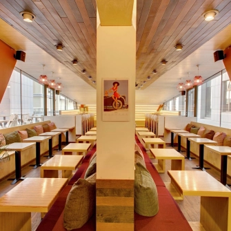 One Love Coffee in Kyiv - symmetrical cafe interior with orange walls and wood ceiling