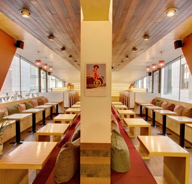 One Love Coffee in Kyiv - symmetrical cafe interior with orange walls and wood ceiling