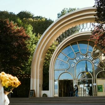 Kyiv Funicular - woman with flowers standing before the arched entrance